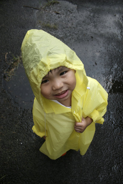 穿着黄色雨衣的男孩微笑着图片下载