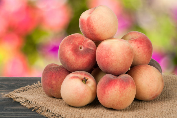 背景模糊的木桌上放着一堆桃子图片下载