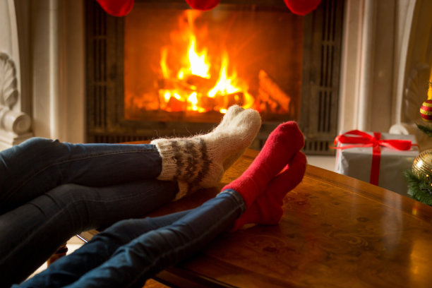 一对夫妇穿着羊毛袜子在壁炉前放松素材图片
