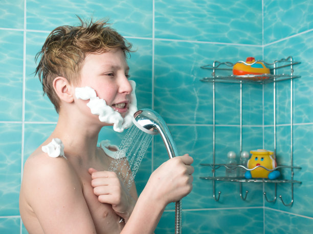 赤裸上身的小男孩拿着喷壶淋浴图片下载