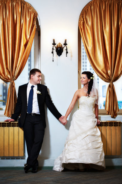 幸福的新娘和新郎在室内彼此牵着手图片下载