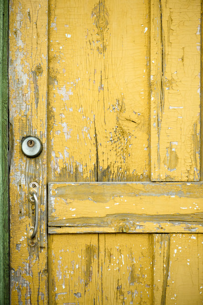 黄色的旧的肮脏的门关闭。图片下载