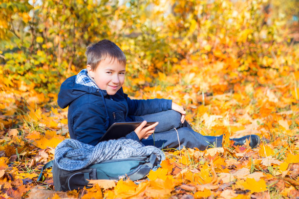 拿着背包和平板电脑的少年图片下载