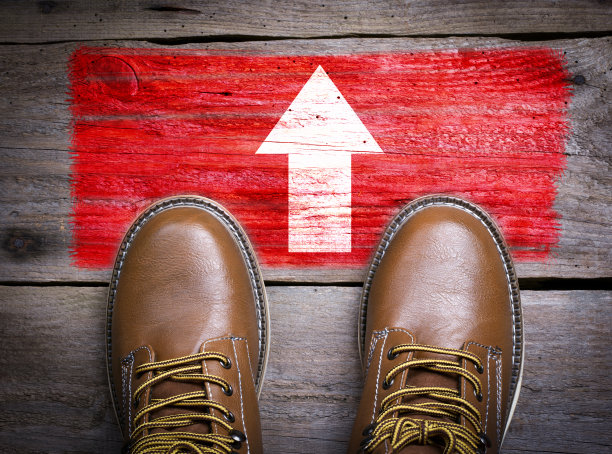 方向箭头。顶部视图的靴子在木制的背景素材图片