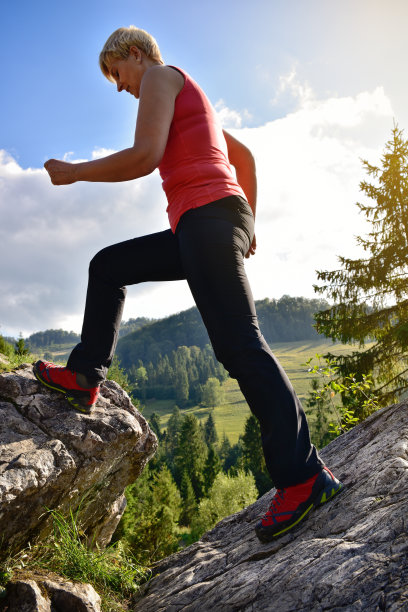 穿着红色登山靴的金发女人在山上行走图片下载
