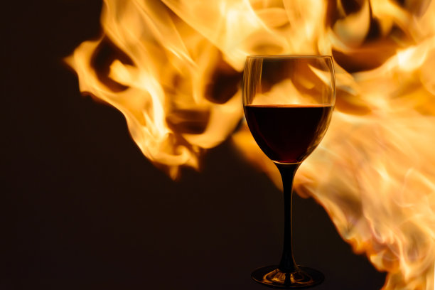 火焰里的一杯红酒。水平的。图片下载