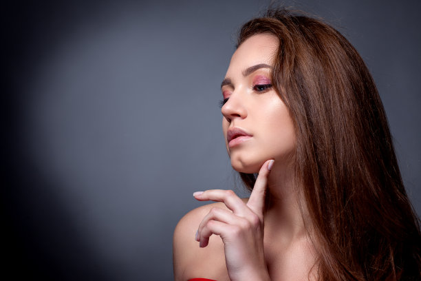 一个美丽女孩的肖像在一个灰色的背景图片下载