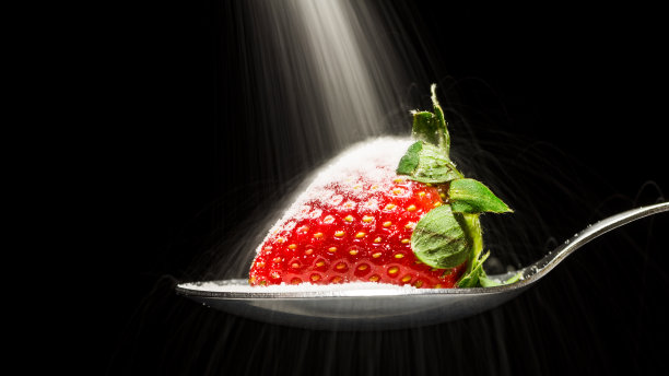 糖倒在勺子上的草莓上图片下载