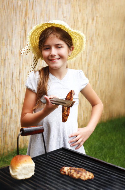 微笑的女孩在烤架上烤肉图片下载
