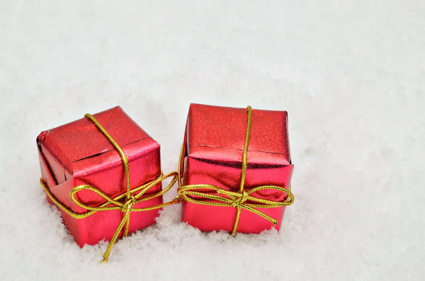 两个红色的礼物包在雪的背景图片下载