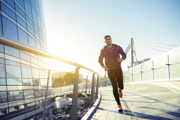 戴着耳机的运动员在城市里跑步素材图片