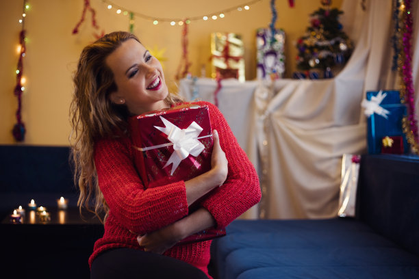 带着圣诞和新年礼物的漂亮女人。图片下载