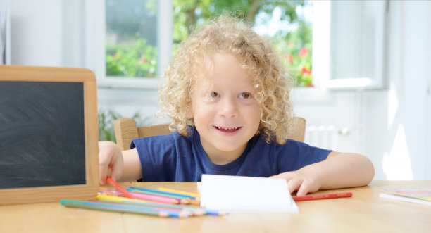 男孩在笔记本上画画图片下载