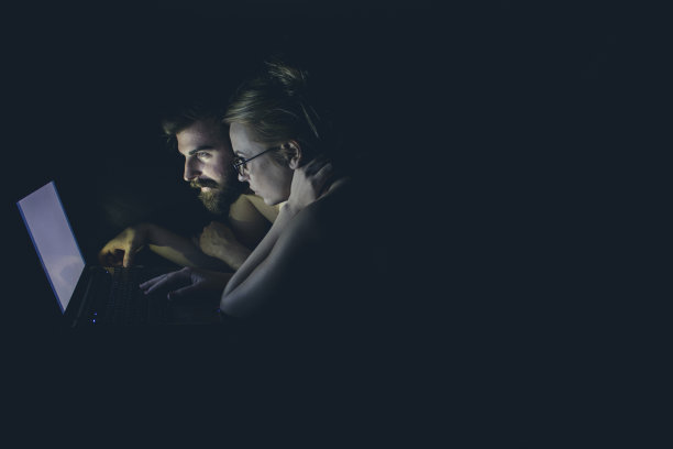 一对可爱的夫妇深夜使用笔记本电脑图片下载