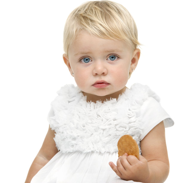看起来很无聊的婴儿手里拿着饼干图片下载