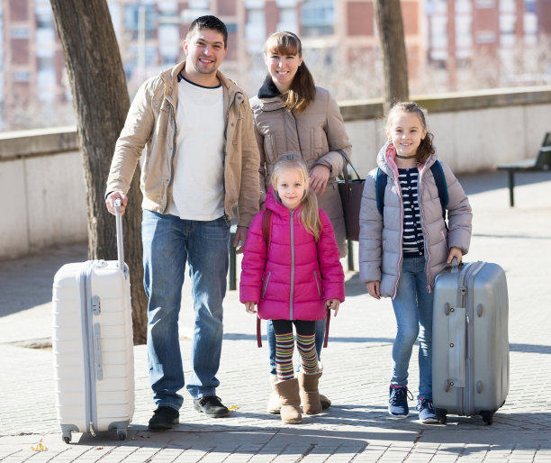 家人带着行李箱在旅途中图片下载