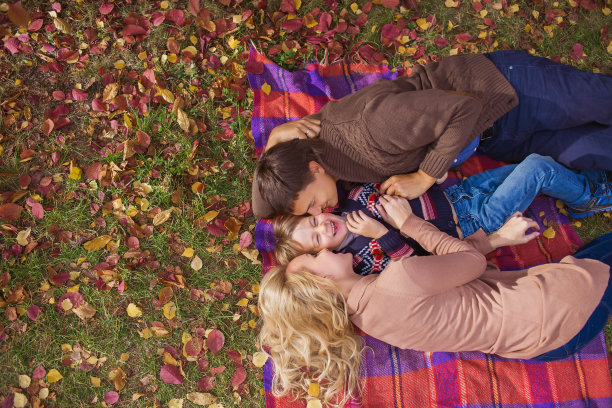 俯视图:年轻的家庭在格子图案上微笑的肖像图片下载