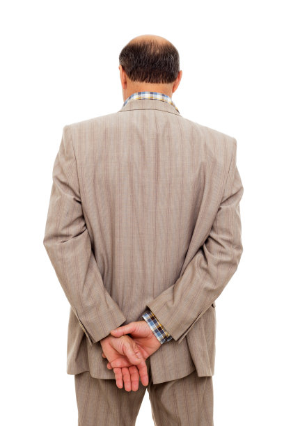 西装男转过身，若有所思地握着手腕图片下载