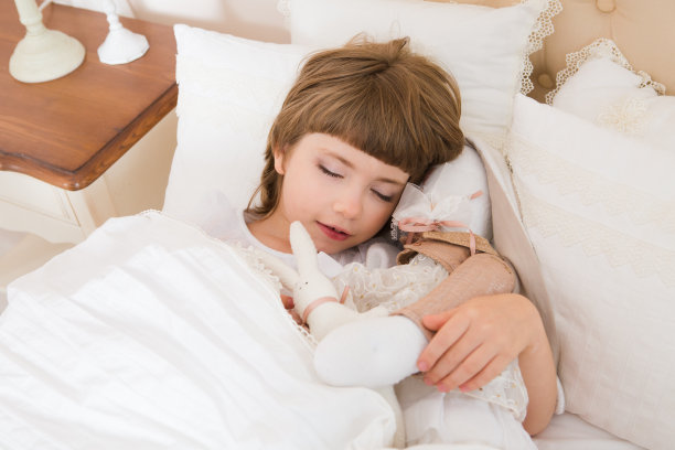 可爱的小女孩睡在床上。图片下载