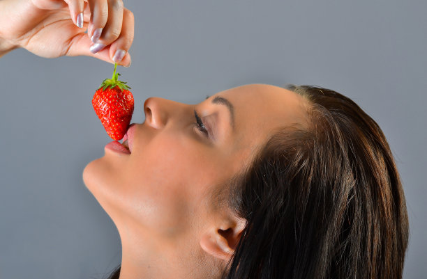 漂亮女孩咬草莓图片下载