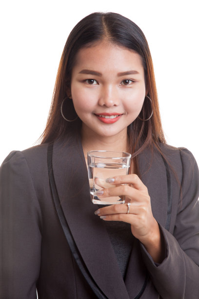 年轻的亚洲女人拿着一杯饮用水。图片下载