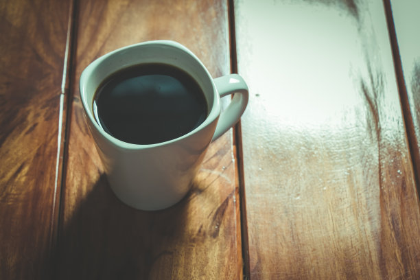 早晨的阳光洒在木桌上，一杯咖啡图片下载