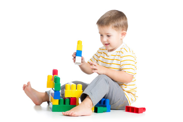 小男孩在白色背景上玩积木玩具图片下载