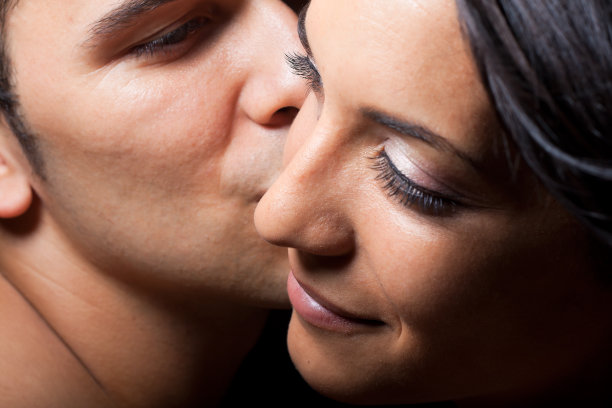 男人俯身亲吻女人的脸颊图片下载