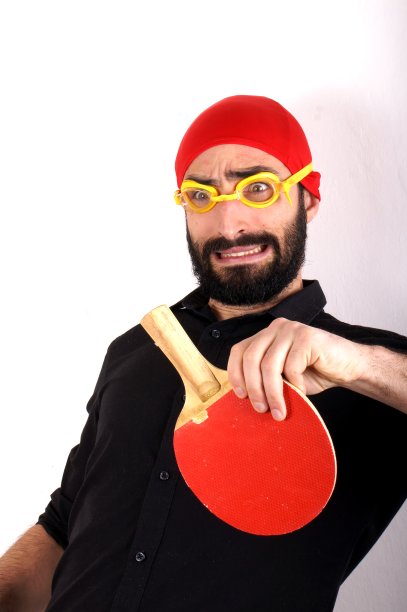 戴着游泳帽打乒乓球的男人图片下载