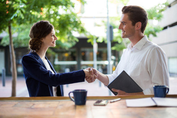 女商人在柜台上和男商人握手素材图片