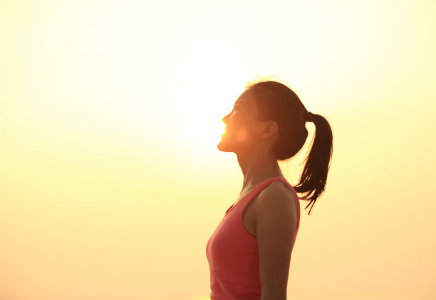 女人站在日出的海滩上图片下载