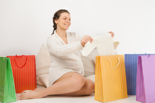 微笑的孕妇打开购物袋图片下载