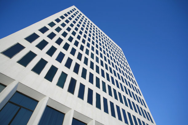 蓝天映衬着白色的办公大楼。图片下载