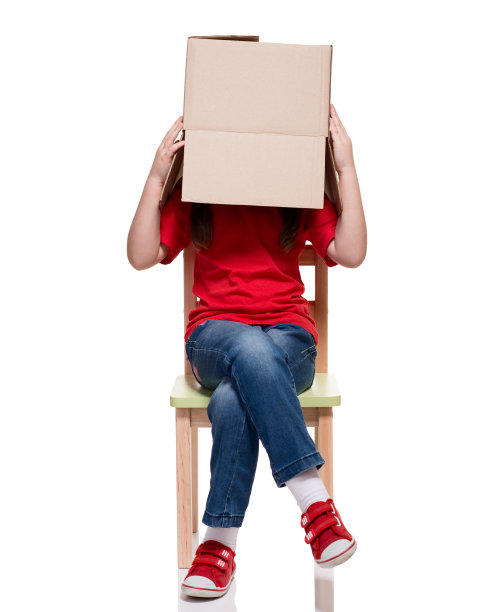 孩子坐在椅子上，头上盖着大盒子图片下载