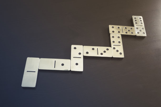 多米诺游戏步骤号在黑色背景上的经营理念图片下载