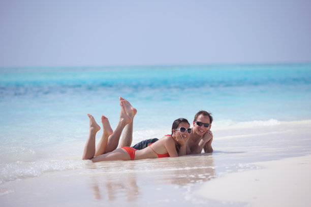 快乐的年轻夫妇在海滩上玩得开心图片下载