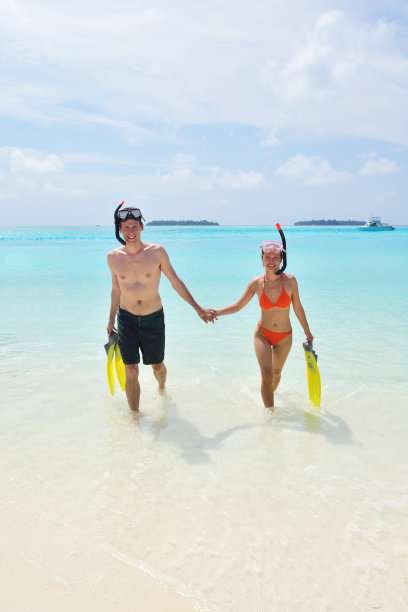 快乐的年轻夫妇在海滩上玩得开心图片下载