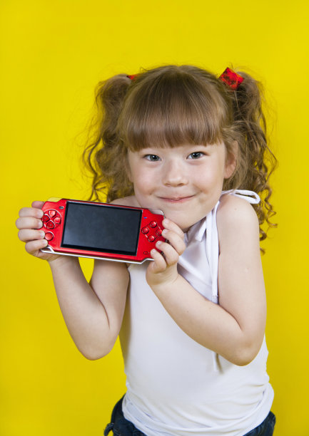 小女孩在玩掌上游戏机图片下载
