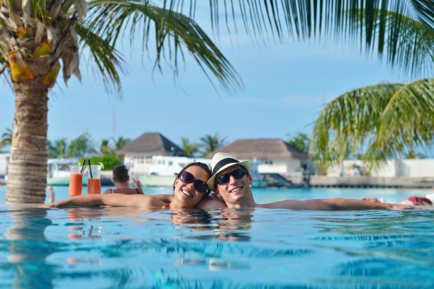 快乐的年轻夫妇在海滩上玩得开心图片下载