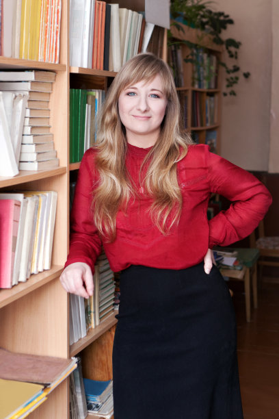 漂亮女人站在书架旁边图片下载