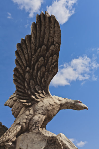 蓝色天空背景上的鸟鹰石雕图片下载