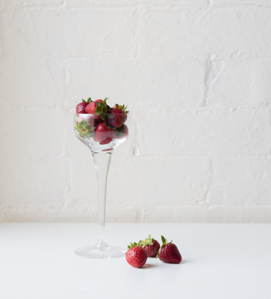 草莓放在酒杯里和桌上图片下载