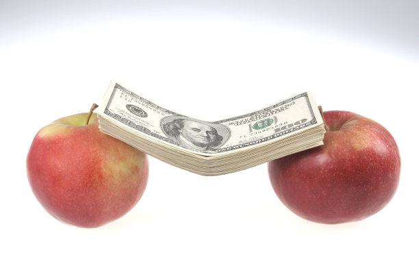 一堆美元放在两个苹果上图片下载