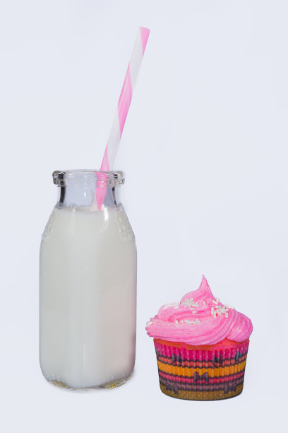 旧奶瓶和粉色磨砂纸杯蛋糕图片下载