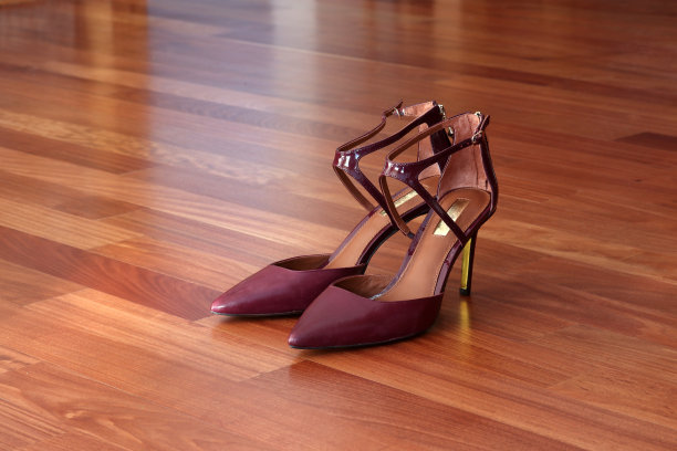 时髦的紫红色高跟鞋在硬木地板上图片下载