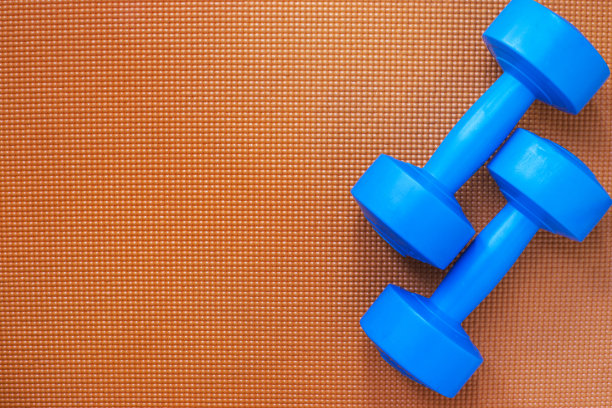 木桌上有哑铃和瑜伽垫素材图片