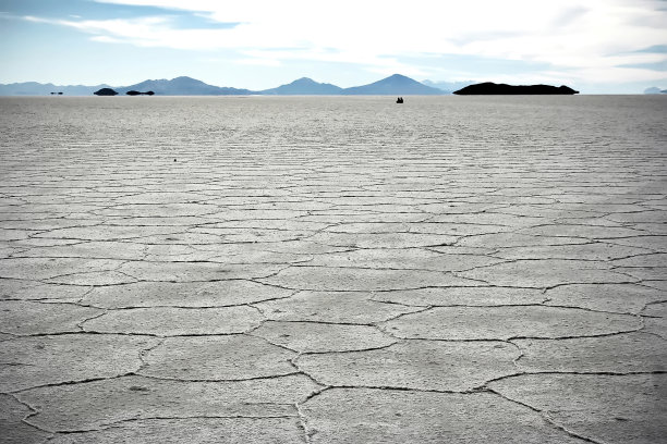 乌尤尼盐湖水面上有两个人。玻利维亚图片下载