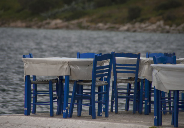 餐馆的桌子和海边的蓝色椅子图片下载