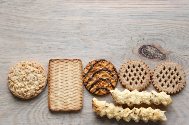 几种饼干与奶酪，巧克力，花生轻木质表面。空的地方。图片下载