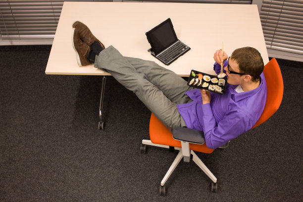 在办公室用筷子吃寿司的男人图片下载